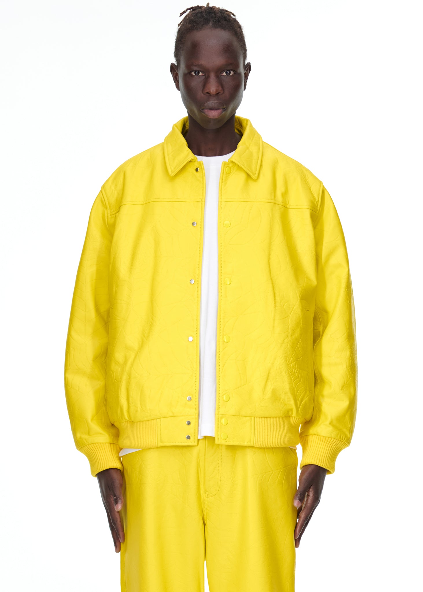 Male model in a bright yellow debossed web cowskin leather jacket with a spread collar and press-stud closure.