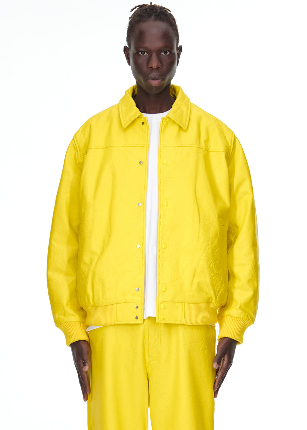 Male model in a bright yellow debossed web cowskin leather jacket with a spread collar and press-stud closure.