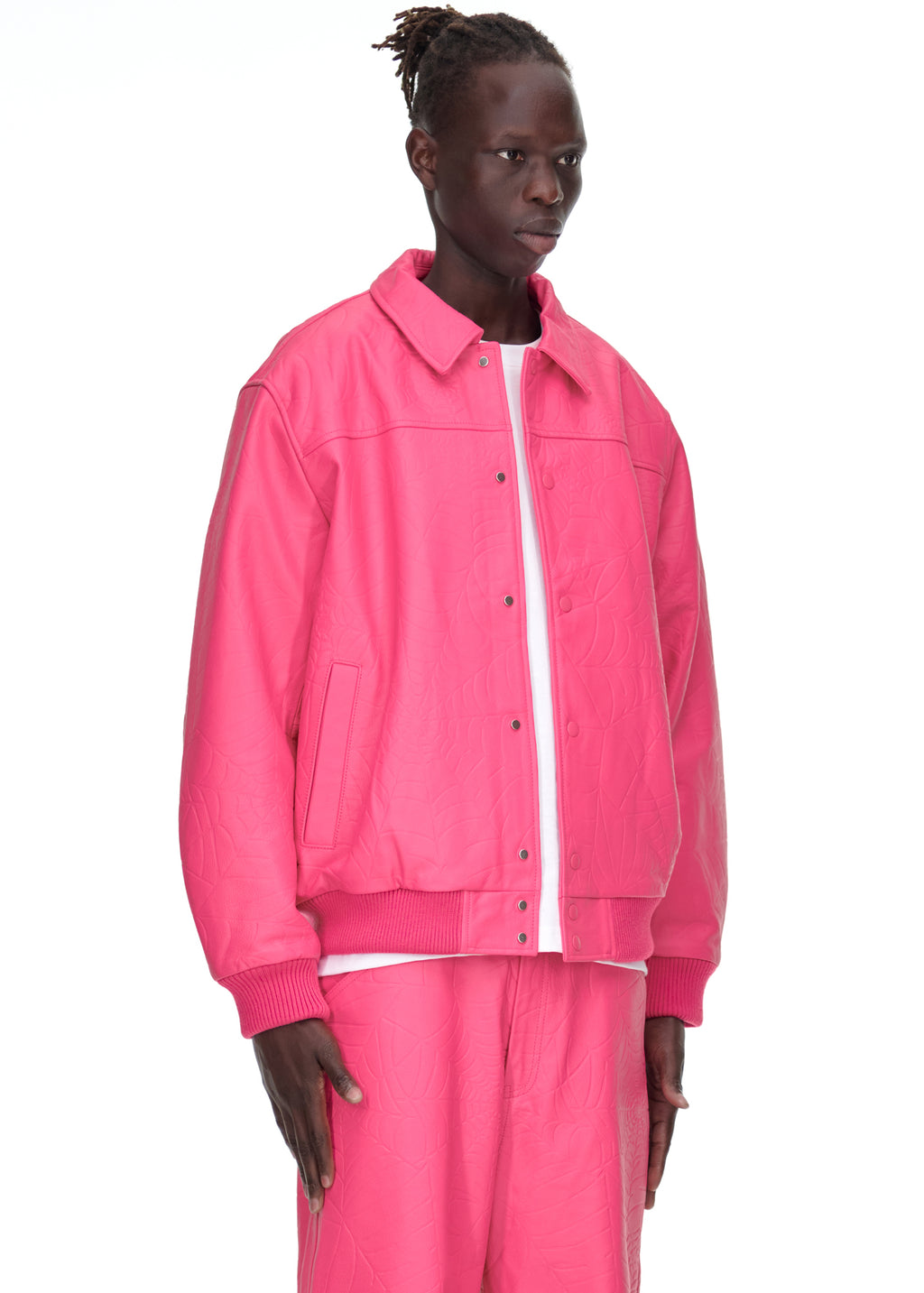 Male model in a pink debossed web cowskin leather jacket with press-stud closure and ribbed trim.