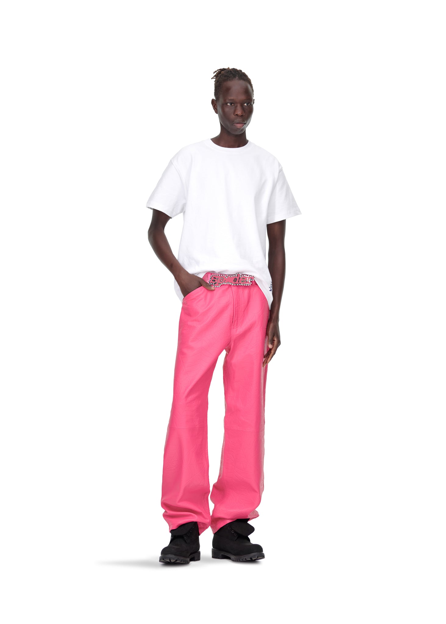 Male model in pink debossed web leather pants, white tee, and black shoes.