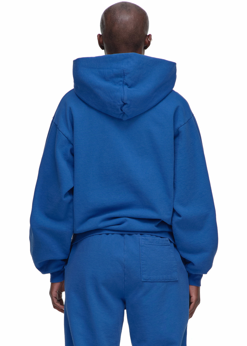Back view of a person wearing a royal blue Legacy Hoodie and matching sweatpants.