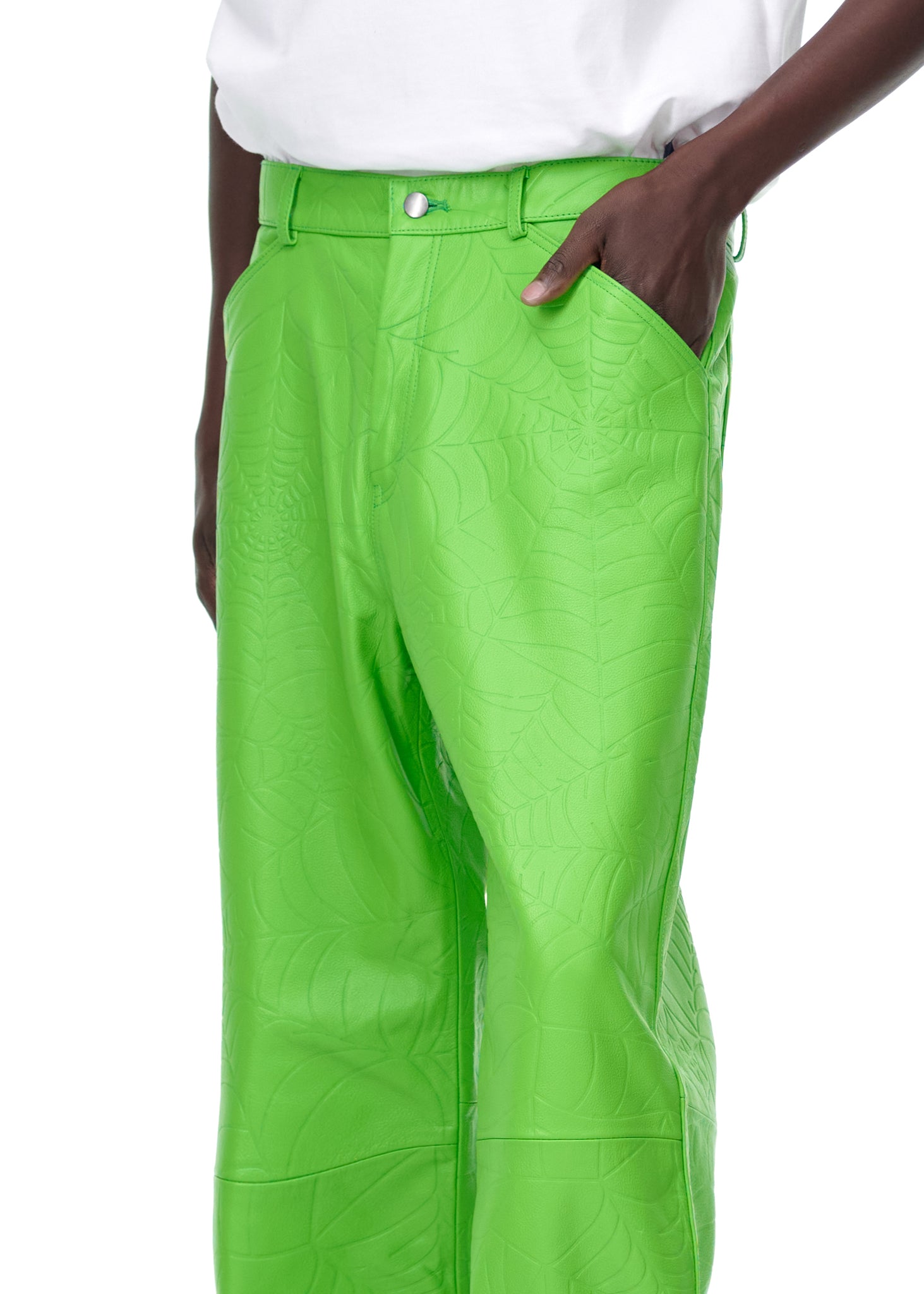 Bright green debossed web leather pants with a pink suede logo patch, worn by a male model.