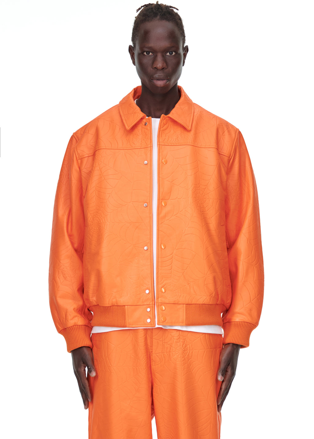 Male model in an orange debossed web cowskin leather jacket with a spread collar and press-stud closure.