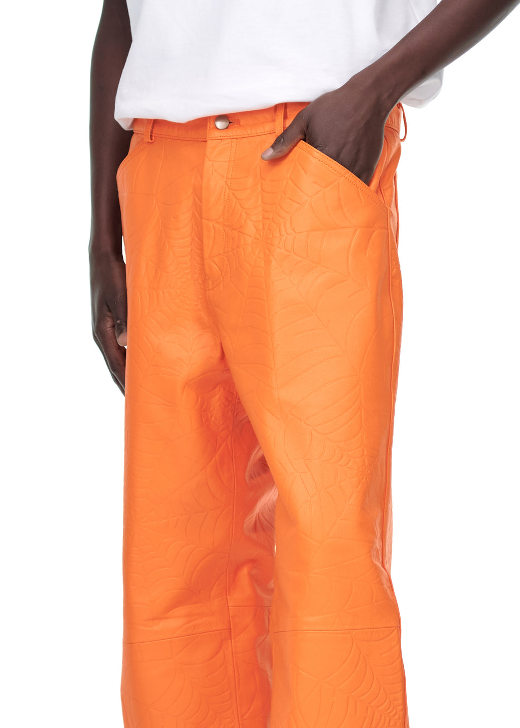 Orange cowskin leather pants with debossed web design, worn by a male model.