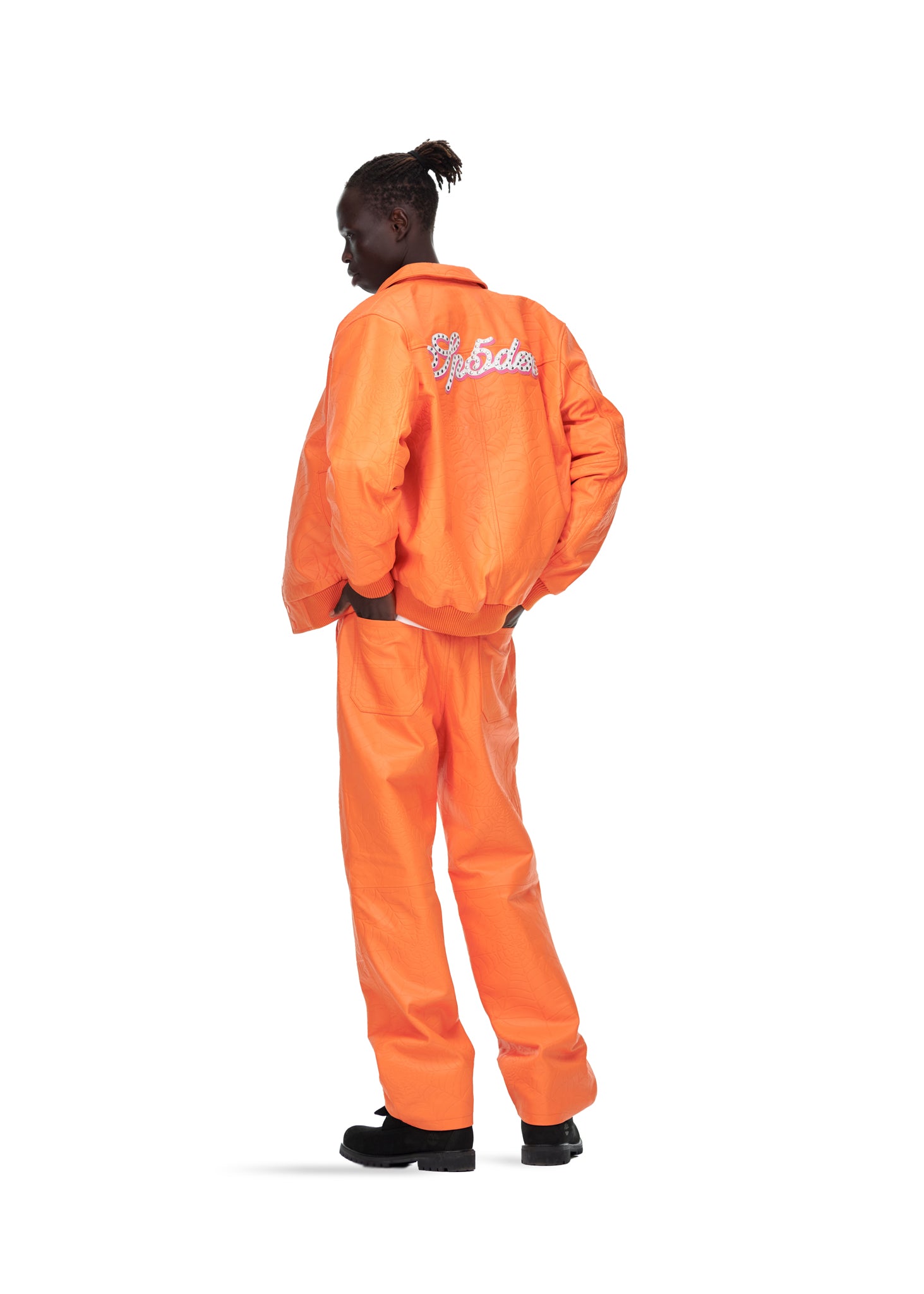 Male model in orange debossed web cowskin leather jacket with studded text on back, size L.