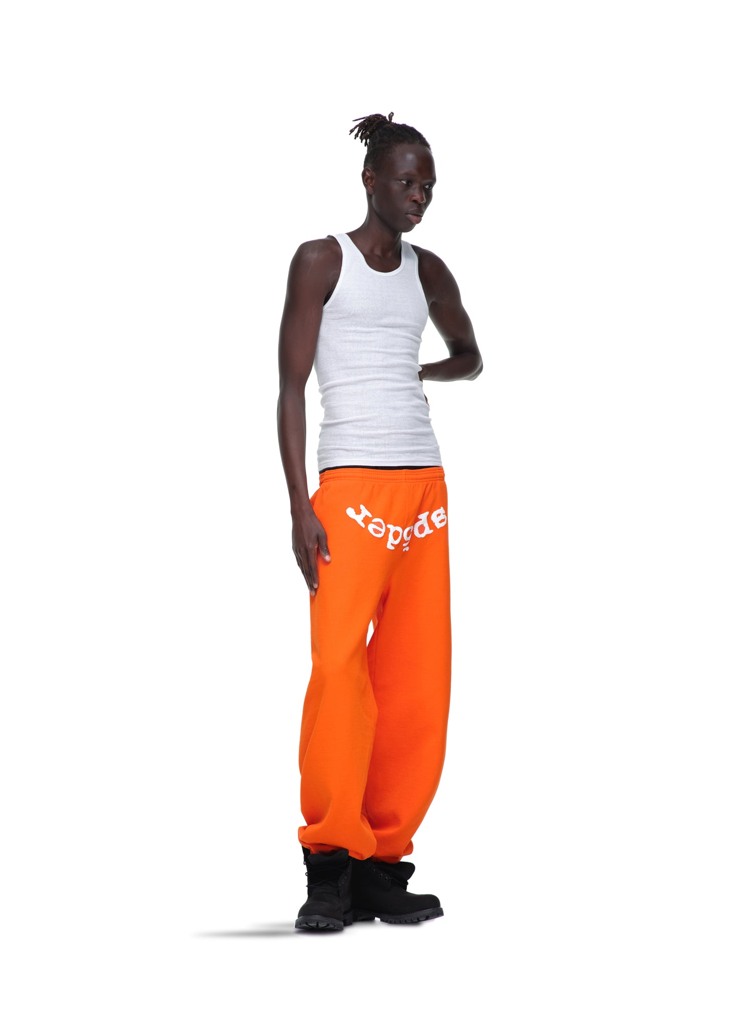 Model wearing orange LEGACY SWEATPANTS with white "spider" puff print, made from 23oz fleece.
