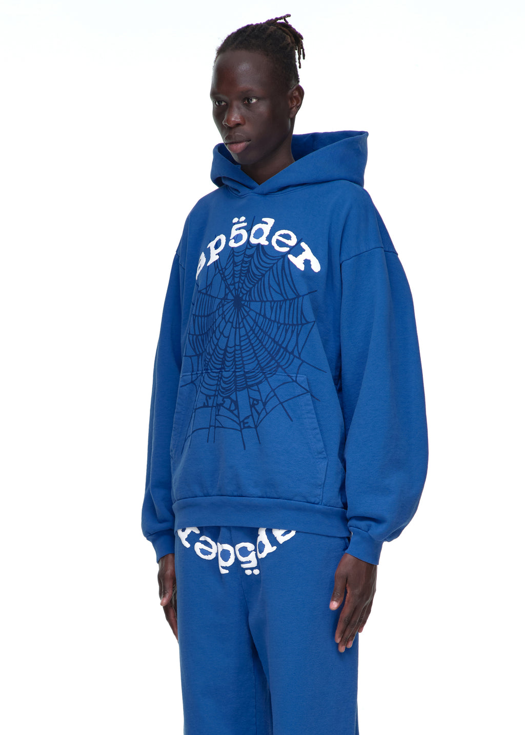 Male model in blue LEGACY HOODIE with white "sp5der" text and black web puff print.
