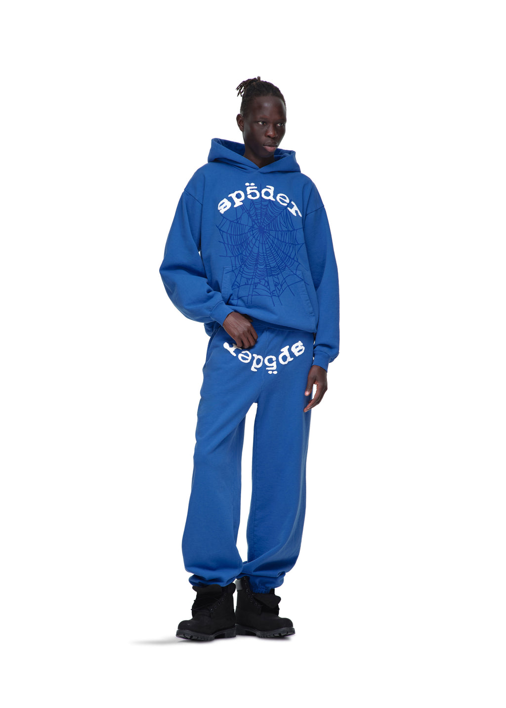 Male model in blue Legacy Hoodie and sweatpants with white SP5DER web and text print.