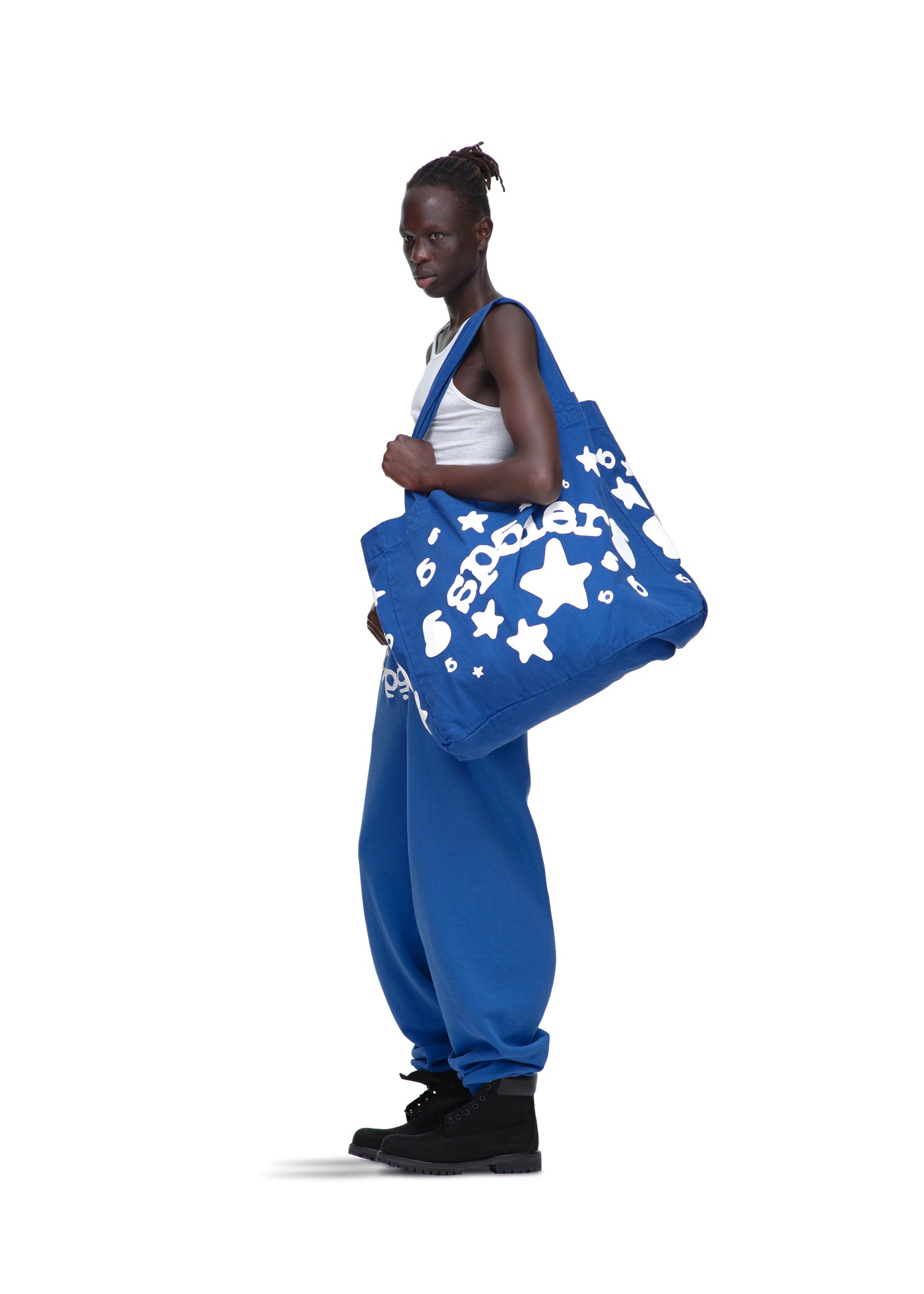 Model holds a large blue Beluga tote bag with white star and text print, made from 8oz brushed twill.