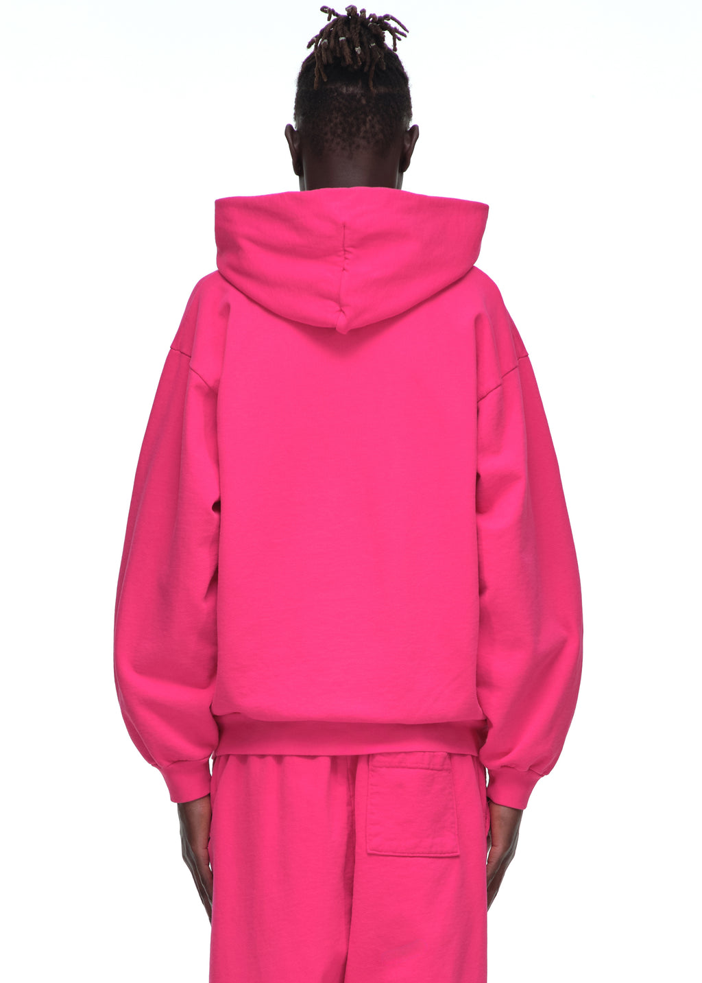 Back view of a male model wearing a bright pink LEGACY HOODIE and matching sweatpants.