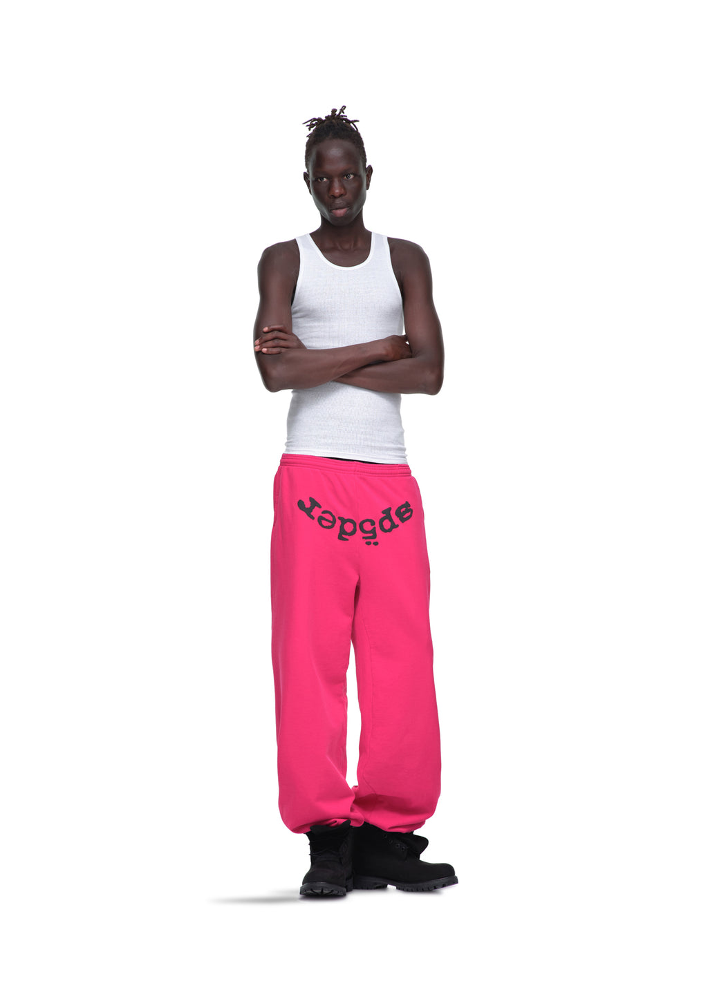 Male model in white tank top and pink LEGACY SWEATPANT with black "sp5der" puff print, black boots.