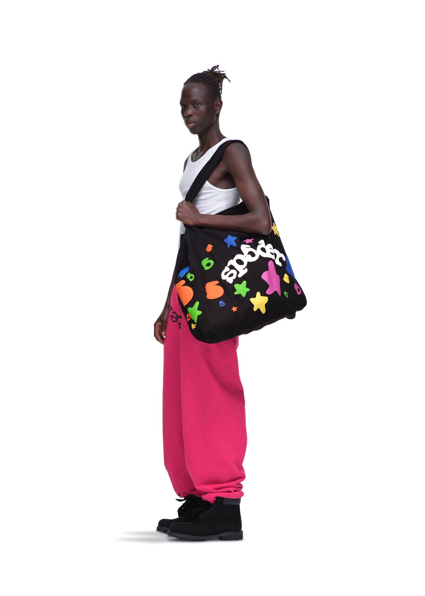 Model wears a black Beluga Tote bag with colorful puff print stars, made from 8oz brushed twill.
