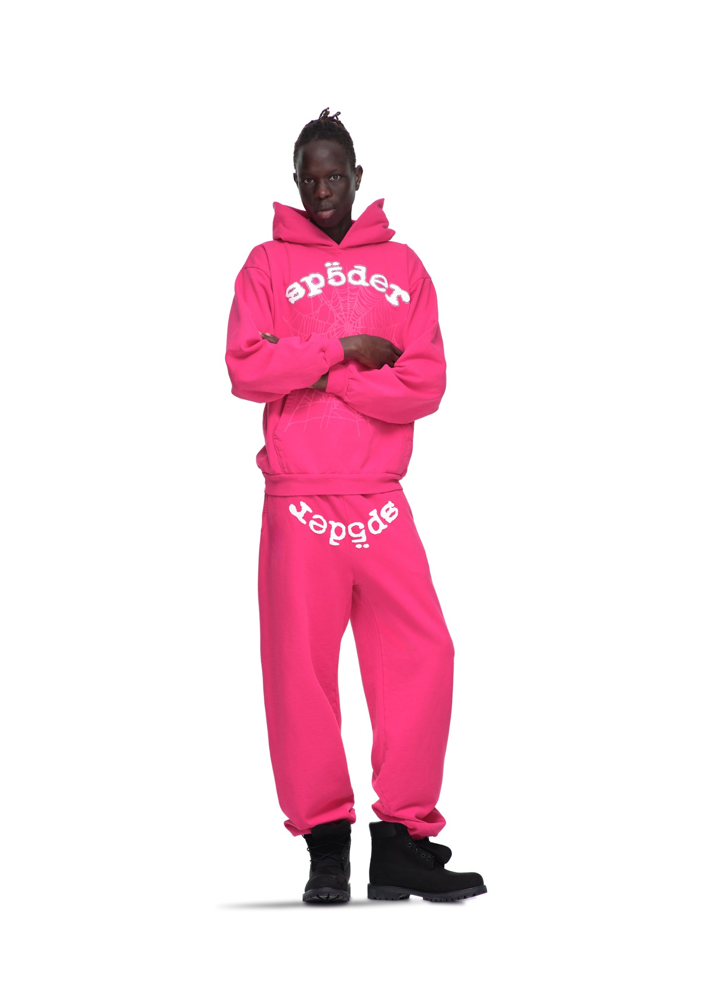 Male model in a pink Legacy Hoodie and sweatpants with white "sp5der" puff print and web design.