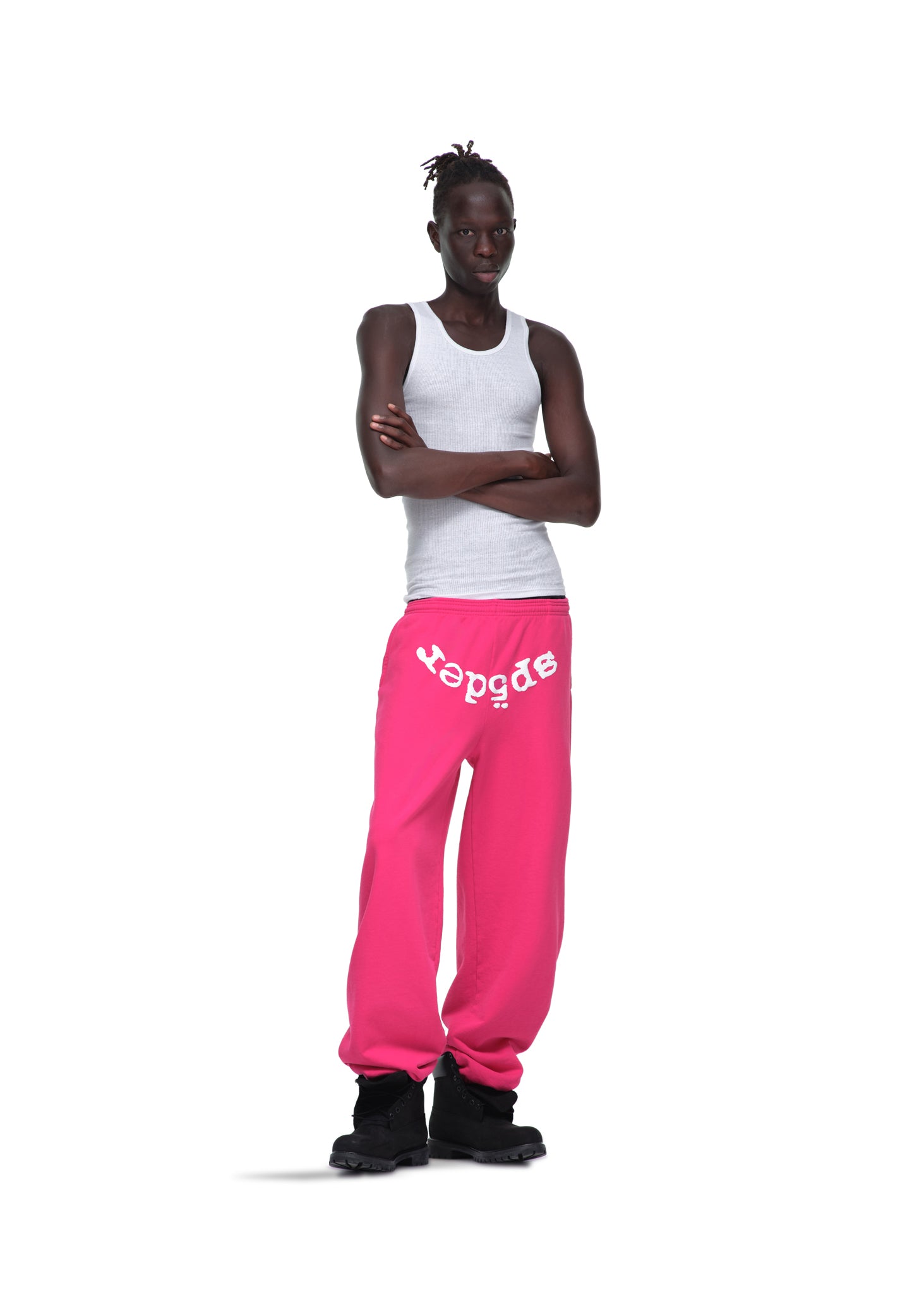 Male model in pink LEGACY SWEATPANT with white "spider" puff print, white tank top, and black boots.