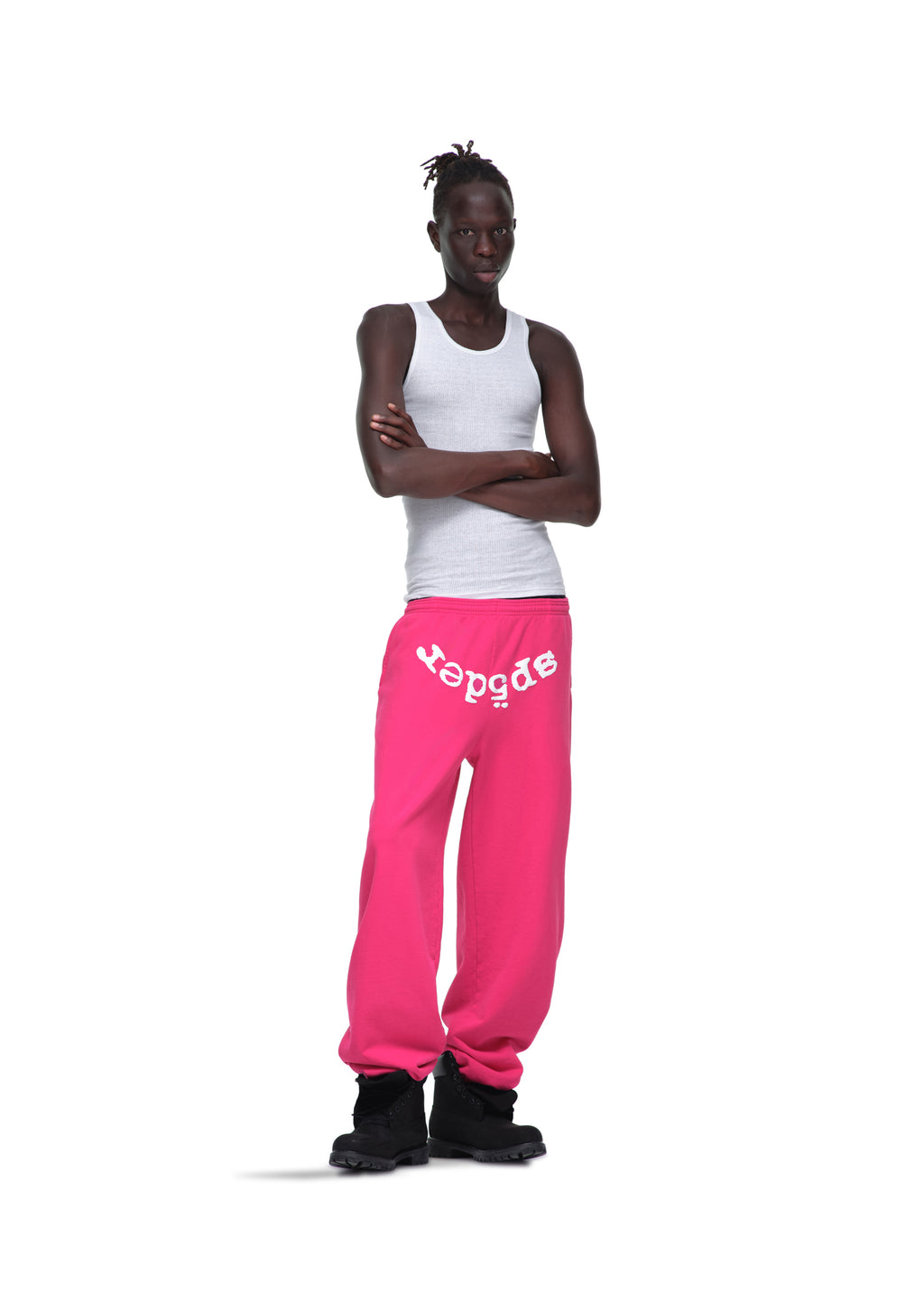 Male model in pink LEGACY SWEATPANT with white "spider" puff print, white tank top, and black boots.