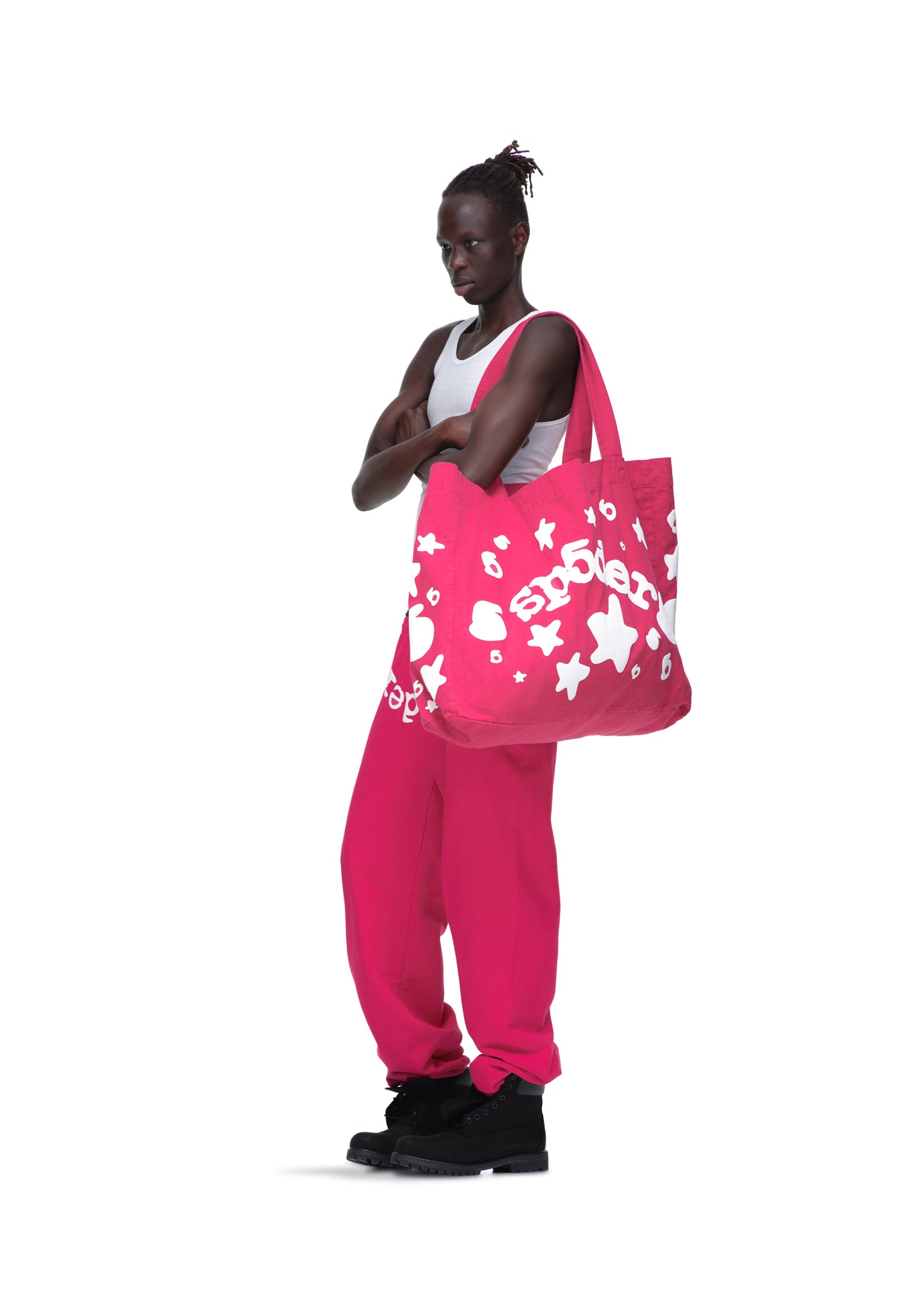 Model wearing a large fuchsia Beluga tote bag with white puff print stars and "spoiler" text, made from 8oz brushed twill.