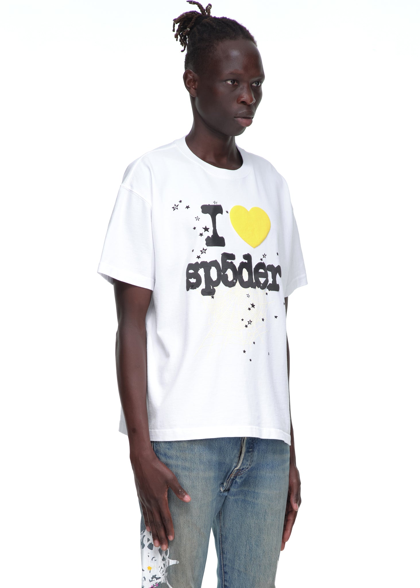 Male model in white 14oz cotton Souvenir Tee with "I ❤️ sp5der" graphic, black stars, and yellow heart.
