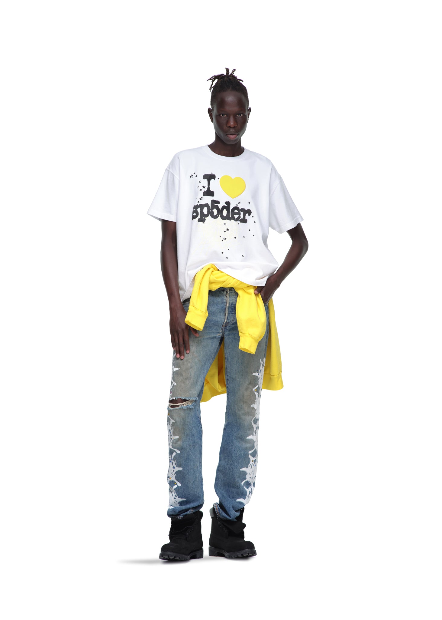 Male model in white 14oz cotton "I ❤️ Sp5der" souvenir tee, distressed jeans, and black boots.