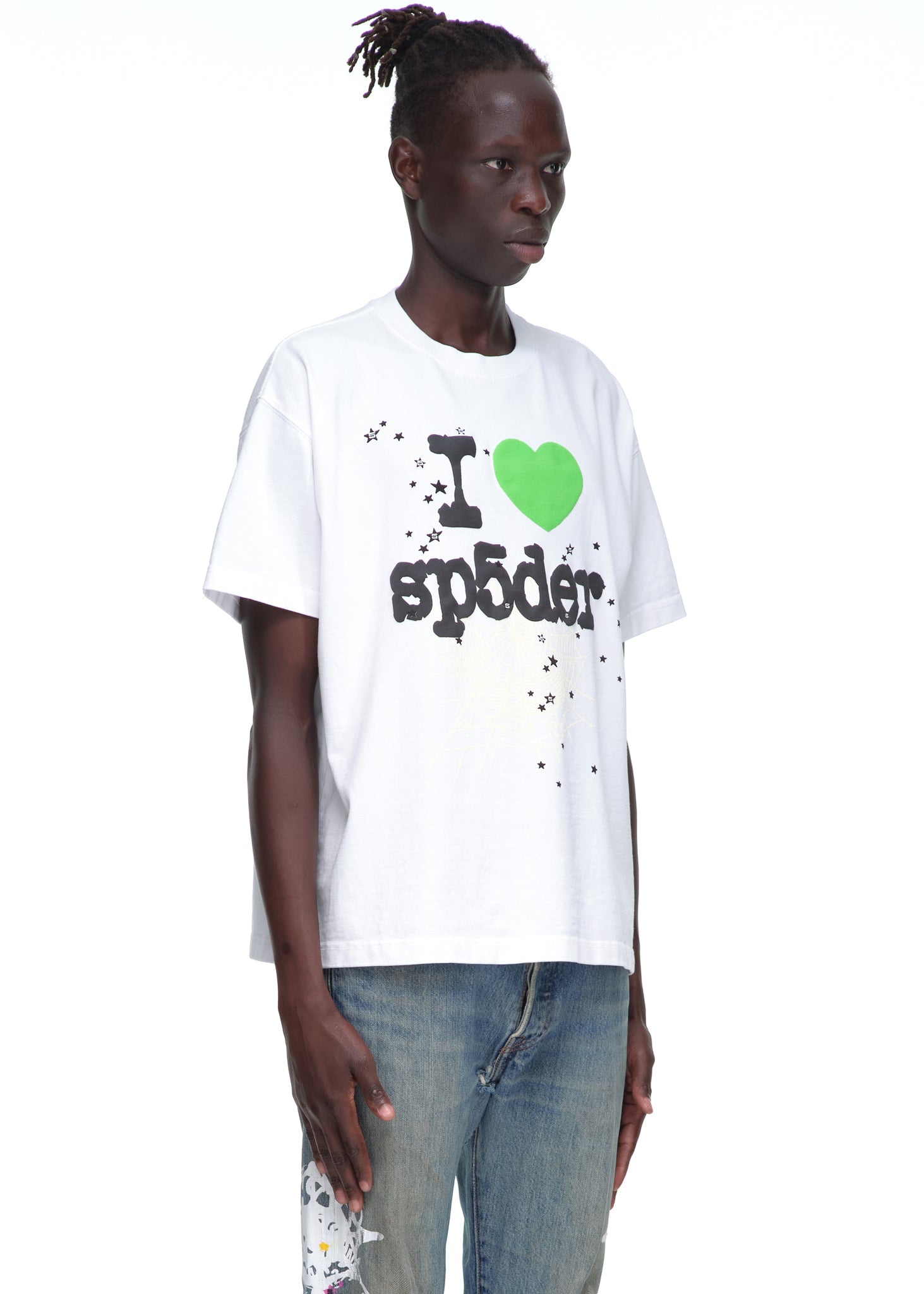 Male model in a white 14oz cotton Souvenir Tee with "I love sp5der" graphic and blue jeans.