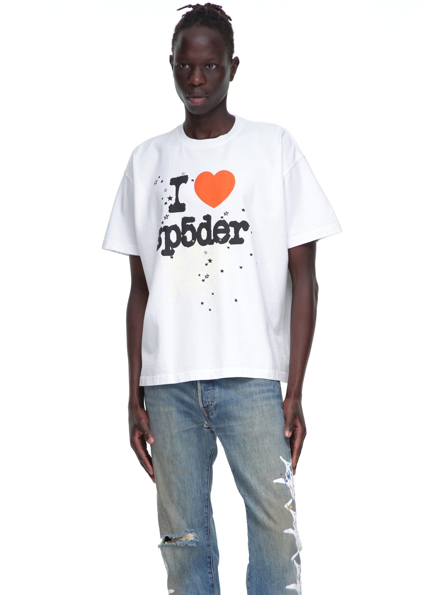 Male model in a white 14oz cotton Souvenir Tee with "I ❤️ Sp5der" graphic, paired with distressed jeans.