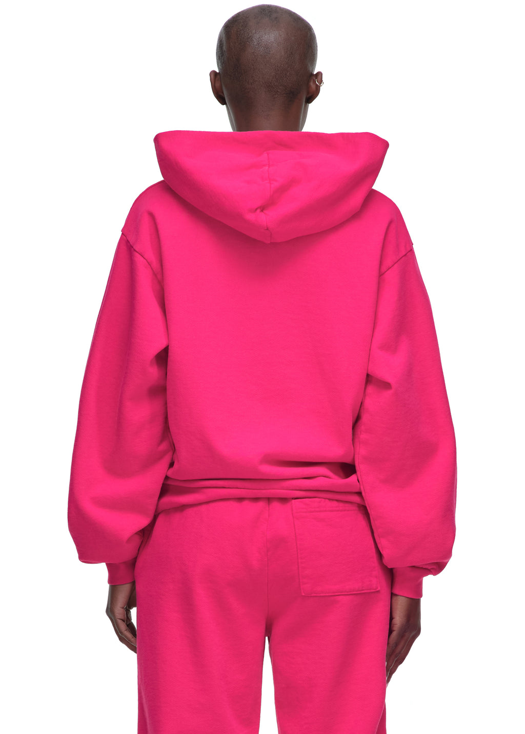 Back of a person wearing a vibrant pink LEGACY HOODIE and matching sweatpants.