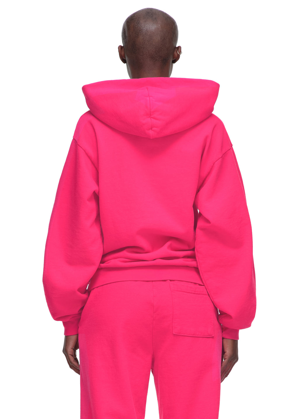 Back view of a person wearing a bright pink 23oz fleece Legacy Hoodie and matching sweatpants.