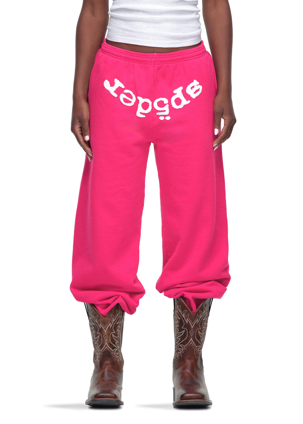Pink 23oz fleece Legacy Sweatpants with white puff print "SP5DER" text, worn with cowboy boots.