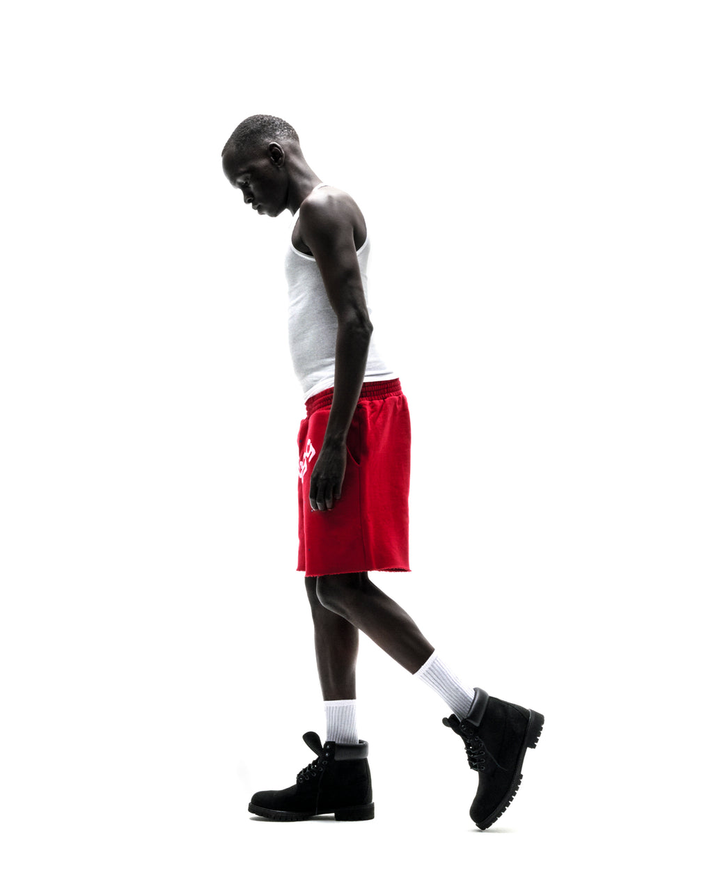Model wearing red ANGEL NUMBER SHORT with white tank top and black boots.