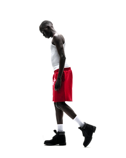 Model wearing red ANGEL NUMBER SHORT with white tank top and black boots.
