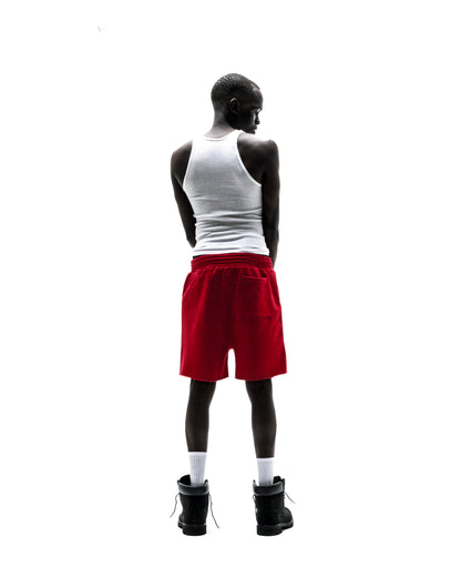 Model wearing red 13oz cotton brushed fleece Angel Number shorts with raw hem and back pocket.