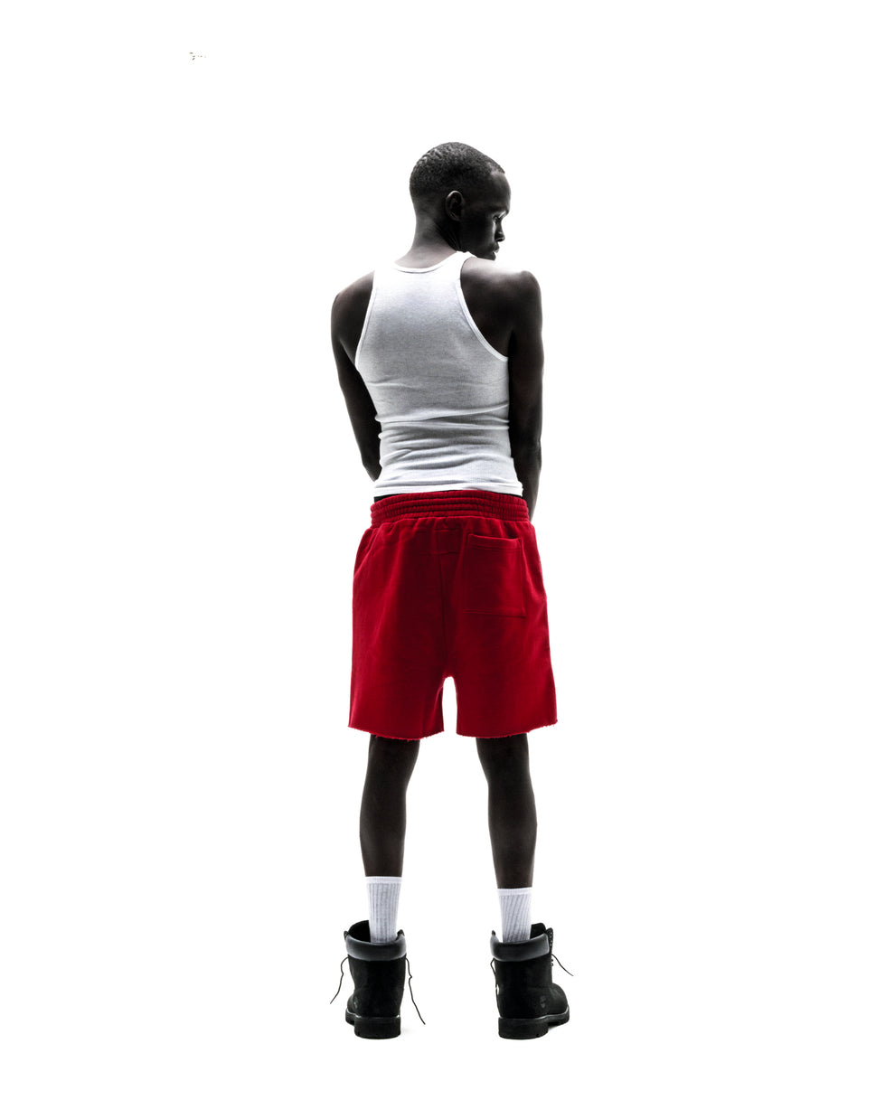 Model wearing red 13oz cotton brushed fleece Angel Number shorts with raw hem and back pocket.