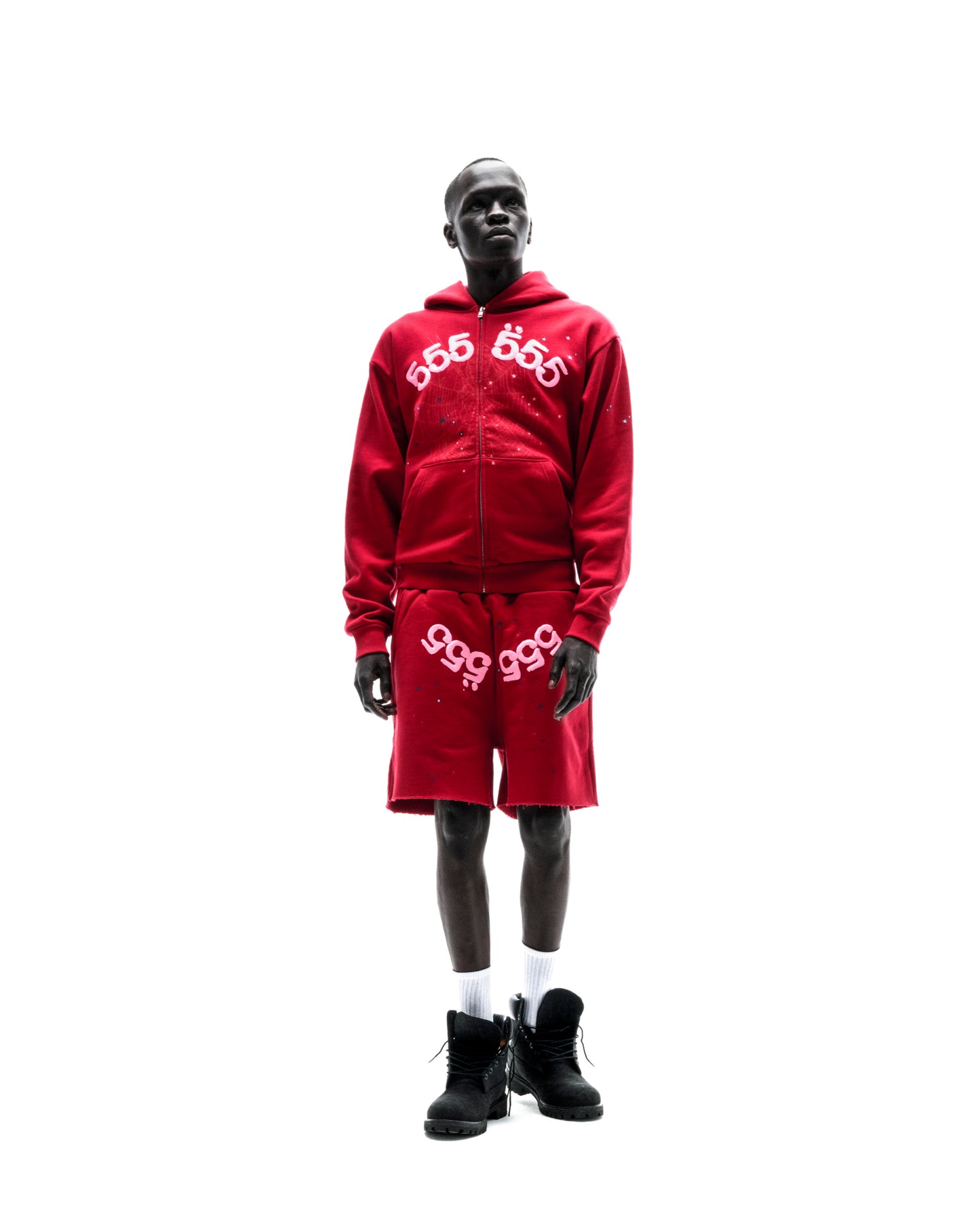 Model wears red 13oz cotton fleece Angel Number zip hoodie and matching shorts with puff print.