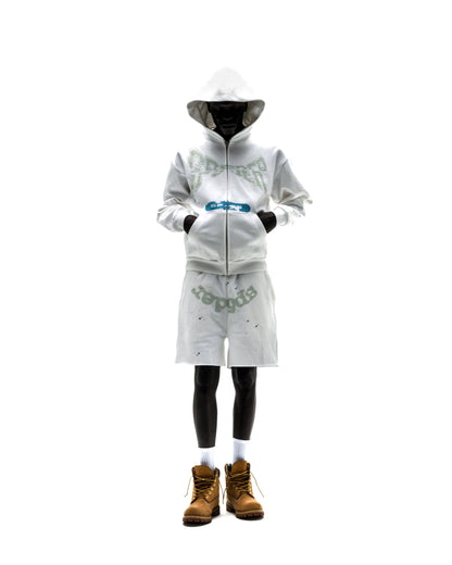 Model in white T&F ZIP UP hoodie and shorts set with puff print, discharge print, and scattered stars.