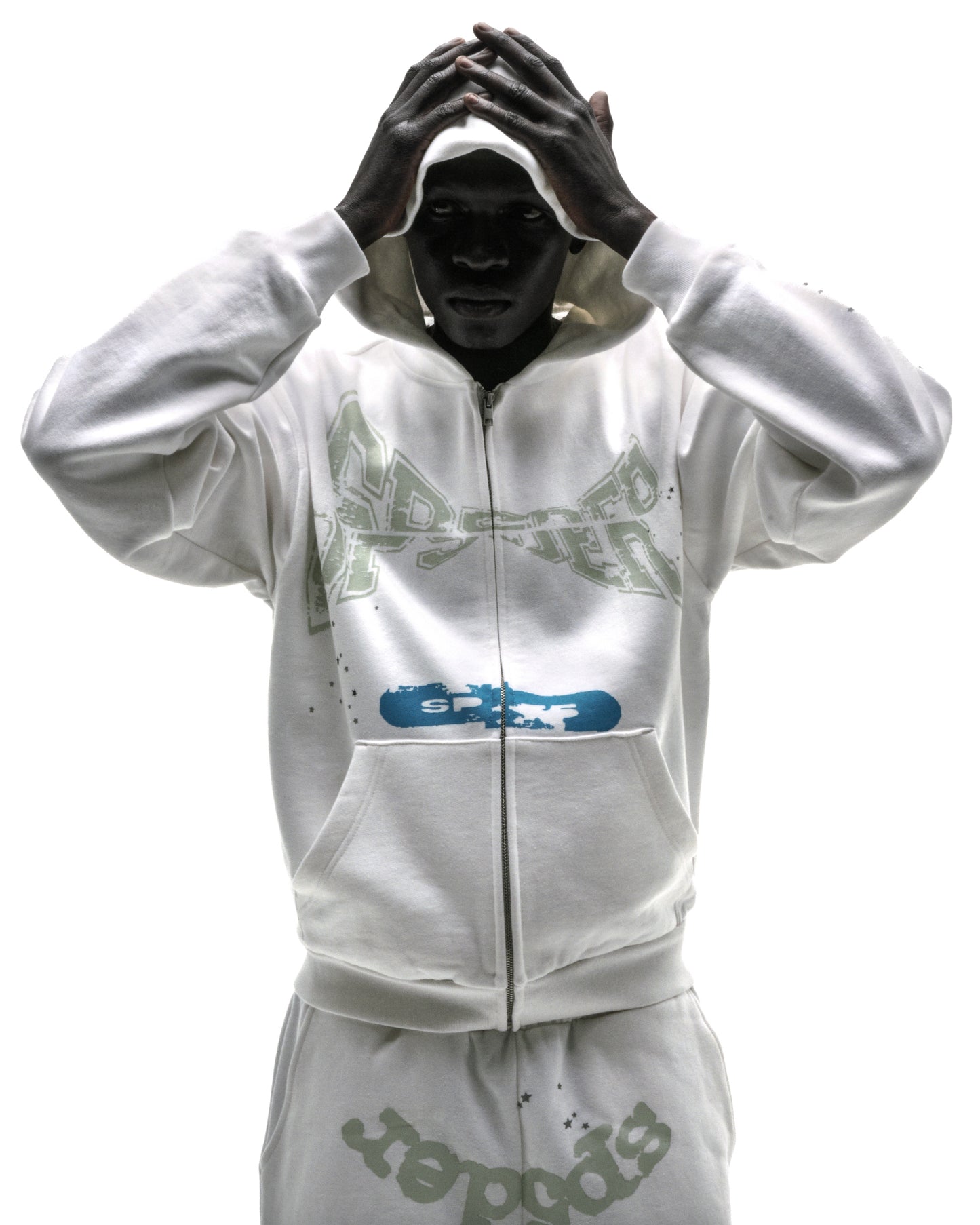 Model wearing a white 13oz cotton fleece T&F zip-up hoodie with puff/discharge print and scattered stars.