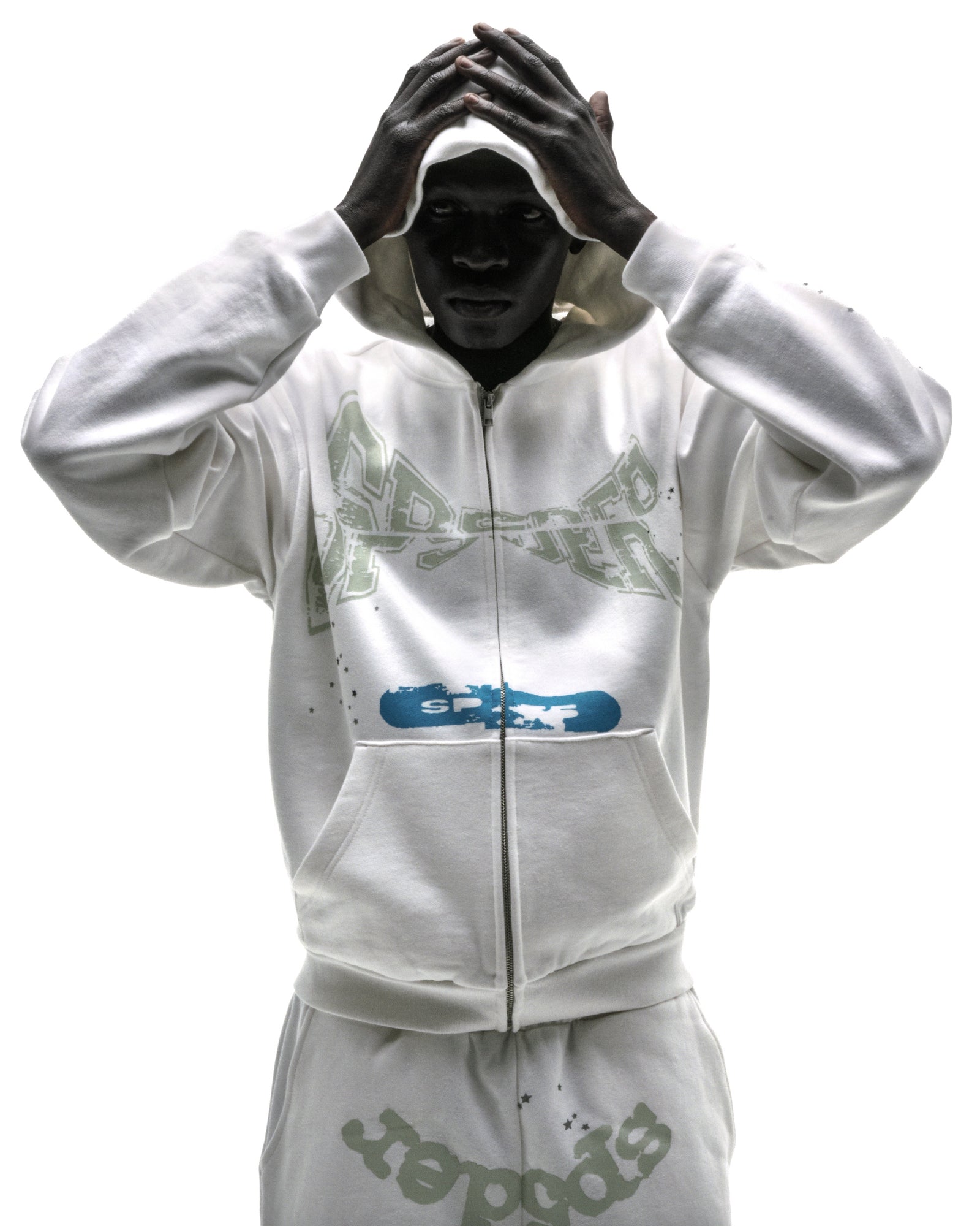 Model wearing a white 13oz cotton fleece T&F zip-up hoodie with puff/discharge print and scattered stars.