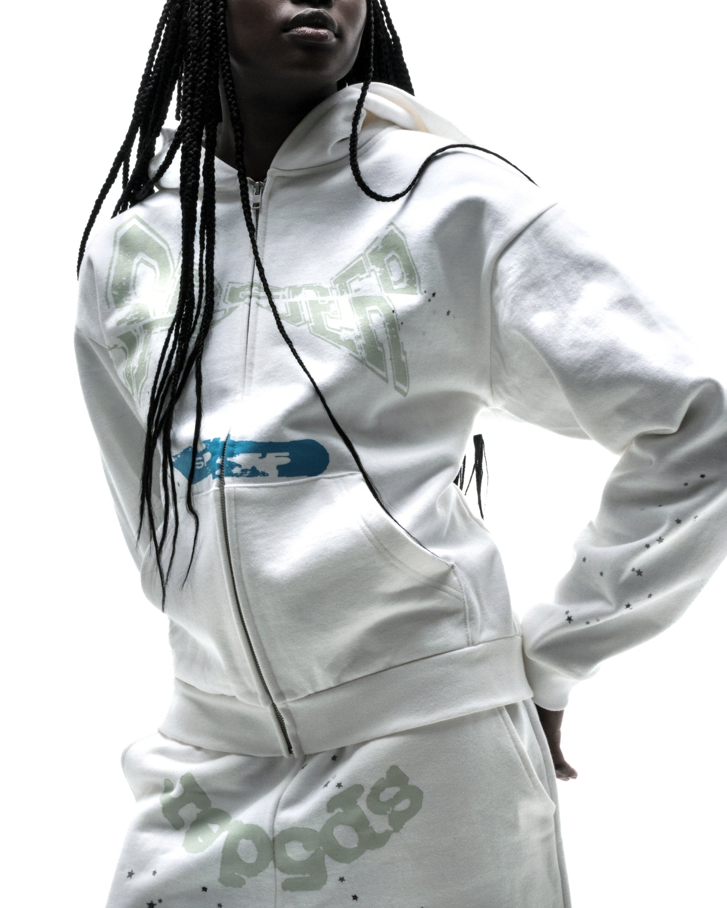 Model in white 13oz cotton fleece T&F zip-up hoodie with puff print and scattered stars.