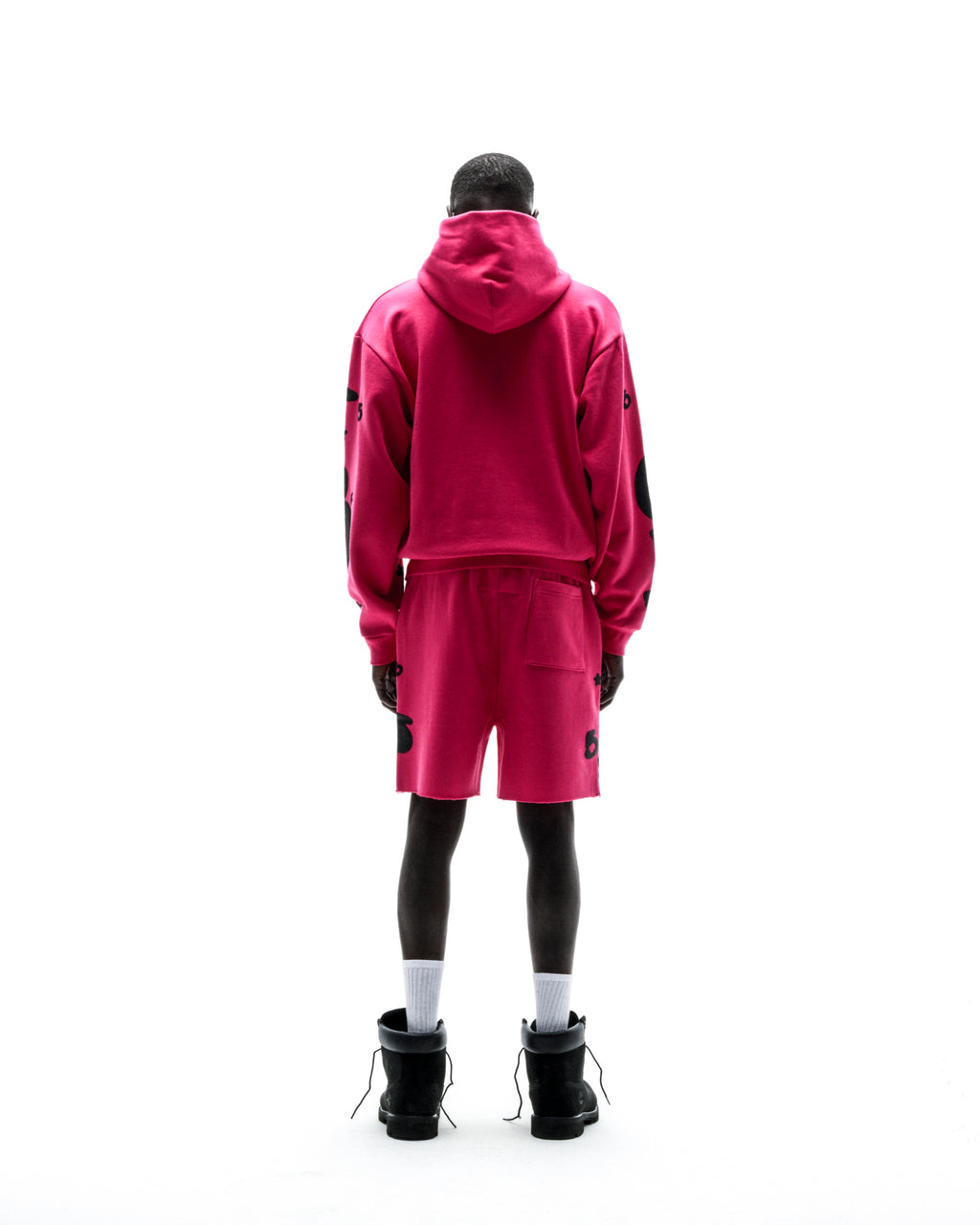 Model from behind wearing a hot pink 13oz cotton fleece Beluga zip-up hoodie and matching shorts.