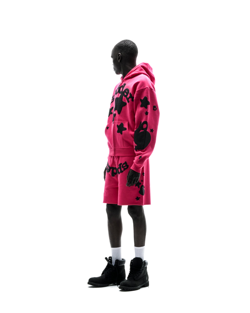 Model in a pink 13oz cotton fleece Beluga zip-up hoodie and matching shorts with black puff print designs.