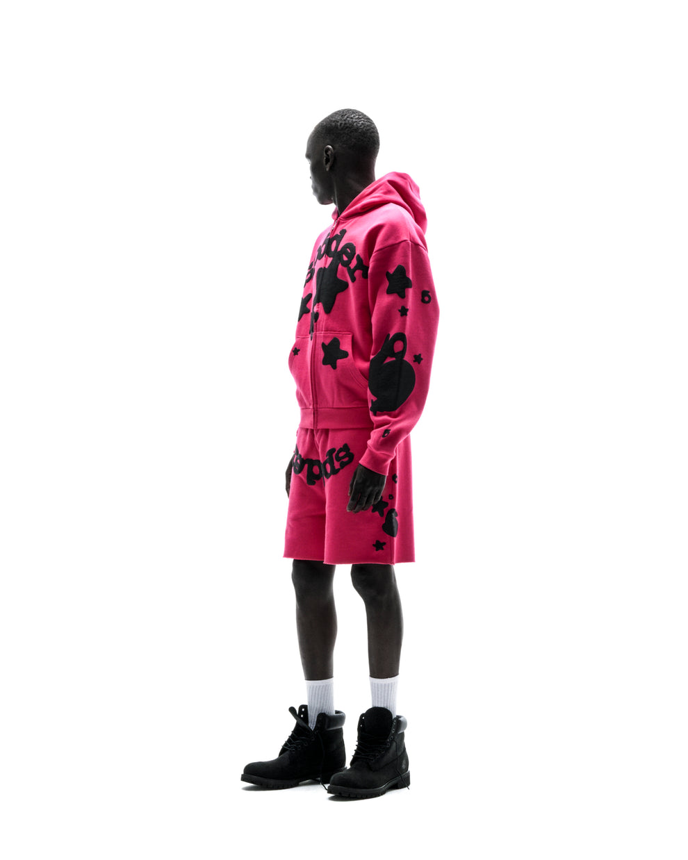 Model in a pink 13oz cotton fleece Beluga zip-up hoodie and matching shorts with black puff print designs.