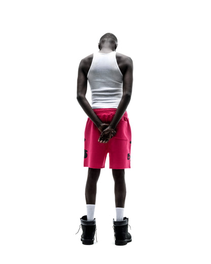 Model from behind wearing pink Beluga sweatshorts with black print, raw hem, and drawcord.