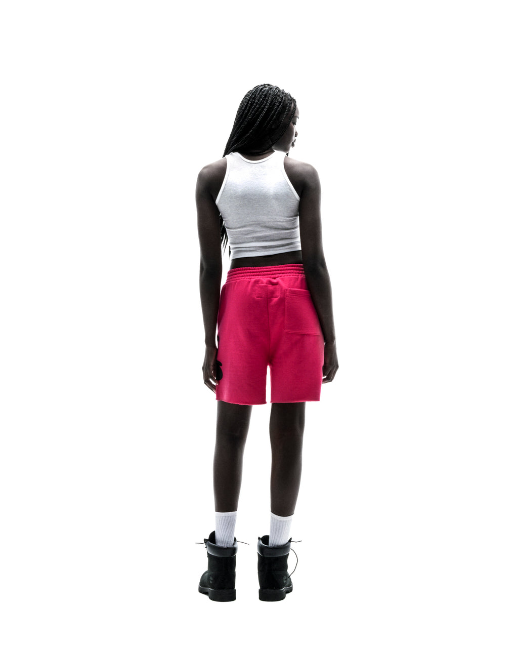 Model from behind wearing bright pink Beluga sweatshorts with a back pocket and raw hem.