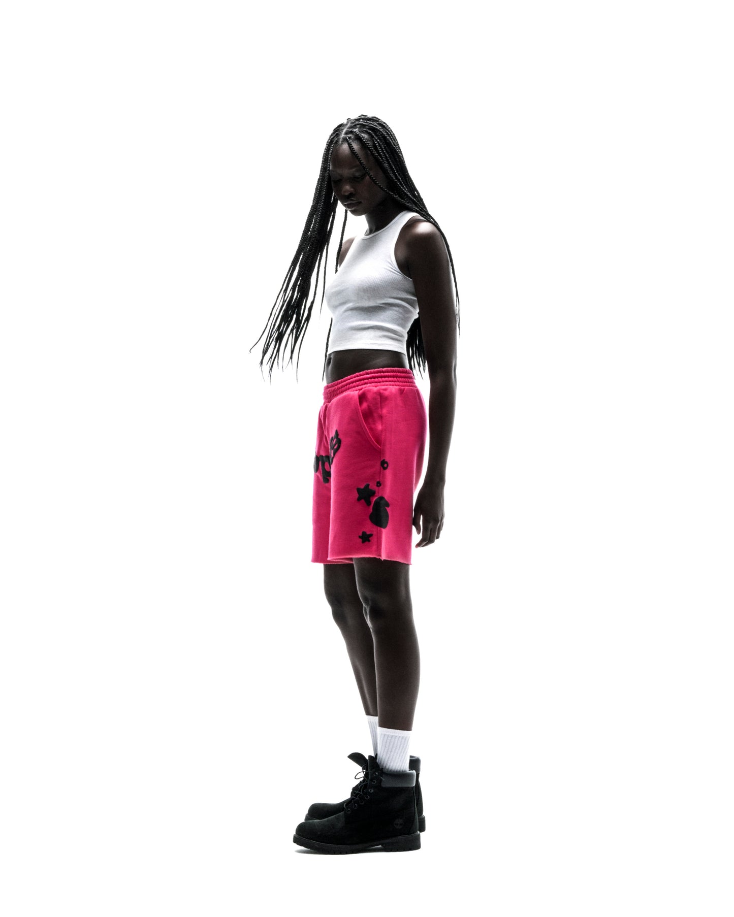 Model in pink Beluga sweatshorts with black print, drawcord, and raw hem.