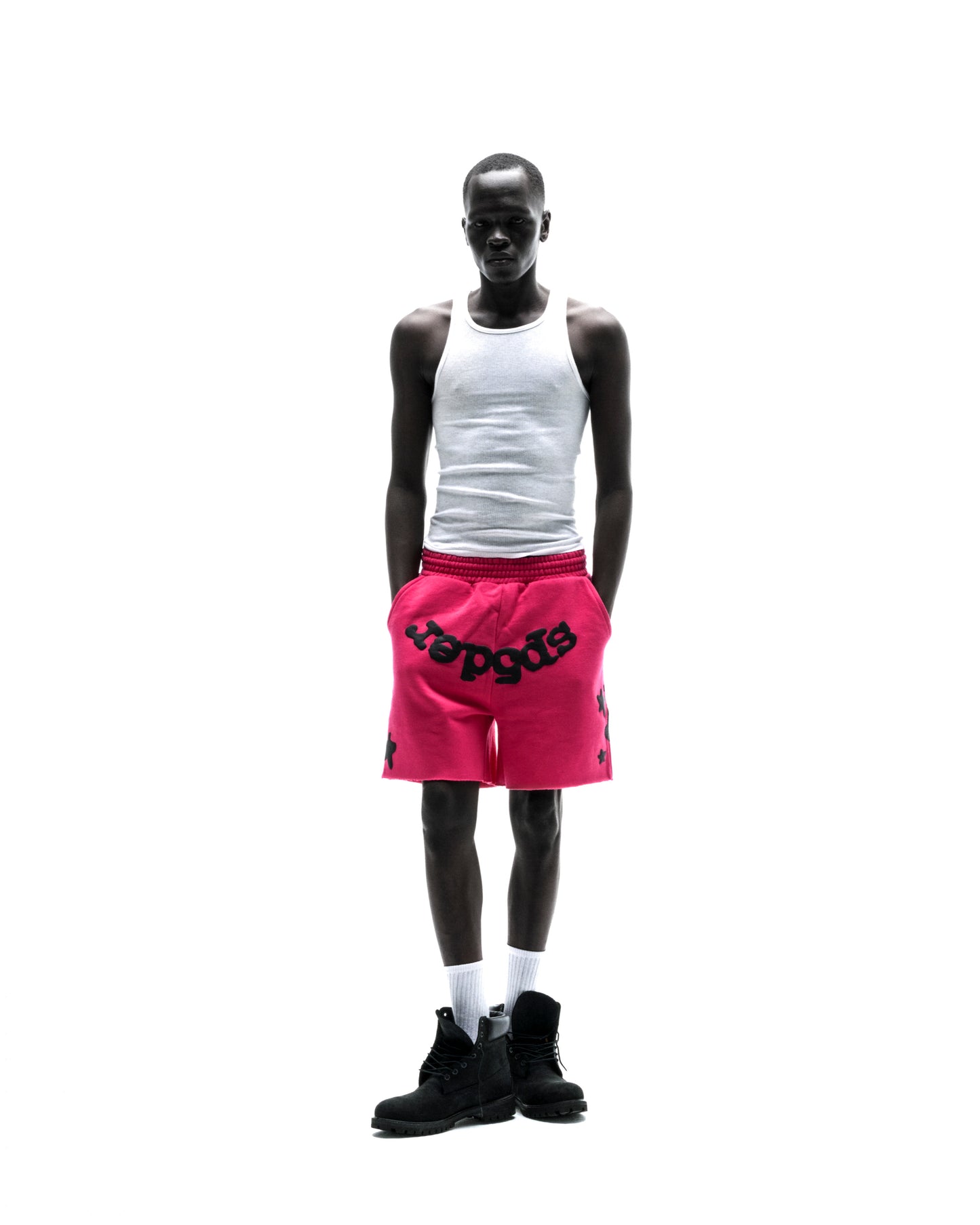 Model wears pink Beluga sweatshorts with black print, drawcord, and raw hem.