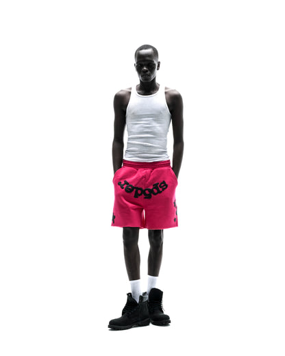 Model wears pink Beluga sweatshorts with black print, drawcord, and raw hem.