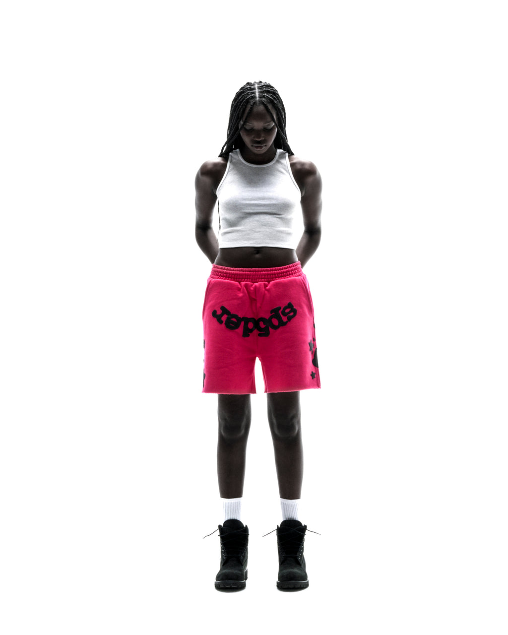 Model in hot pink Beluga sweatshorts with black print, white tank top, and black boots.