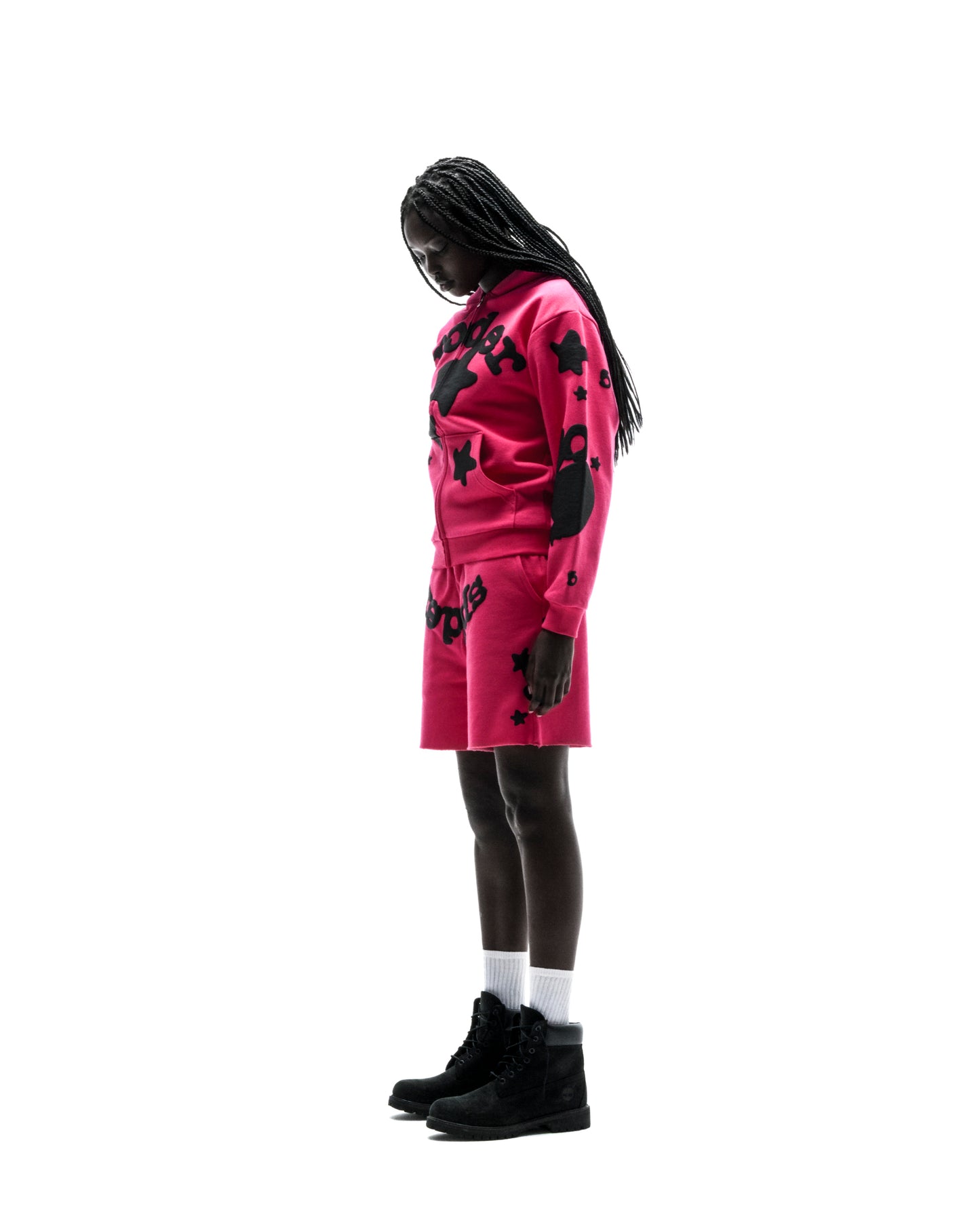 Model in a pink 13oz cotton fleece Beluga Zip Up hoodie and matching shorts with black puff print designs.