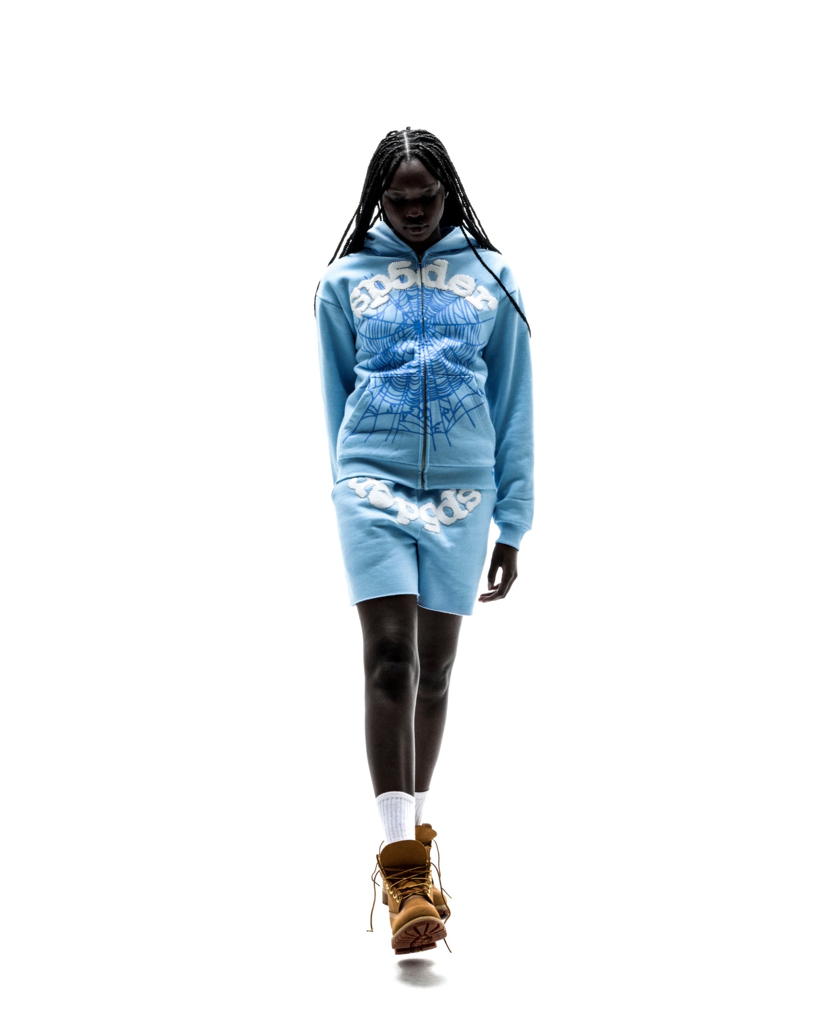 Model wearing light blue OG WEB ZIP UP hoodie and shorts set with white spiderweb print.