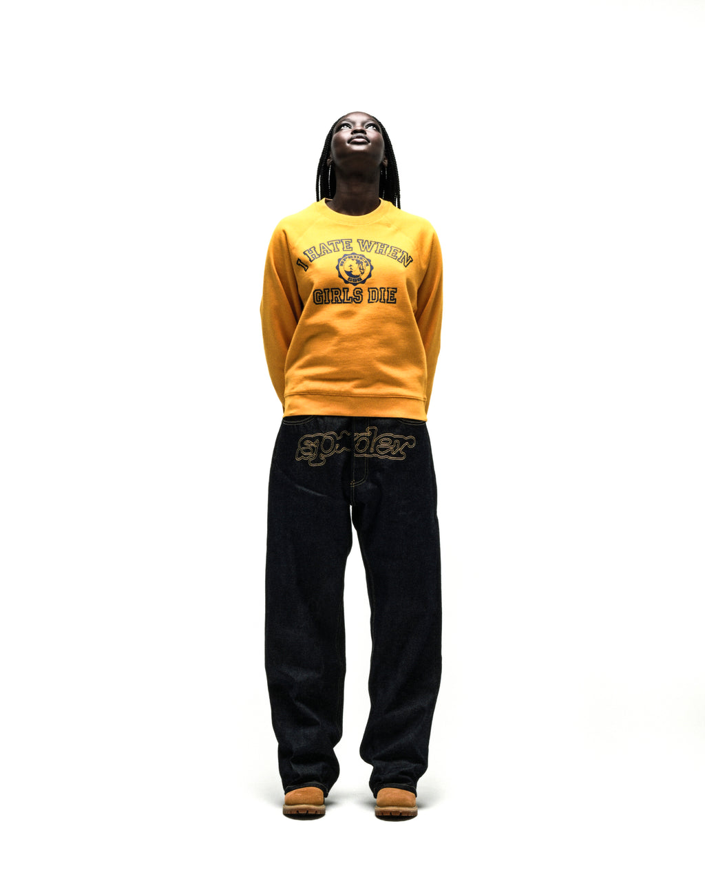 Mustard yellow 100% cotton raglan crewneck with graphic print, ribbed collar, and cuffs worn with dark denim jeans.