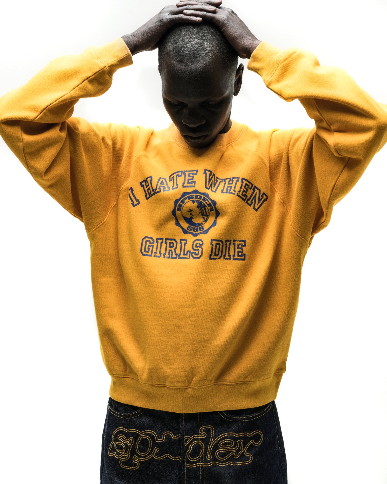 Yellow 100% cotton raglan crewneck with blue graphic print on front, ribbed collar, hem, and cuffs.