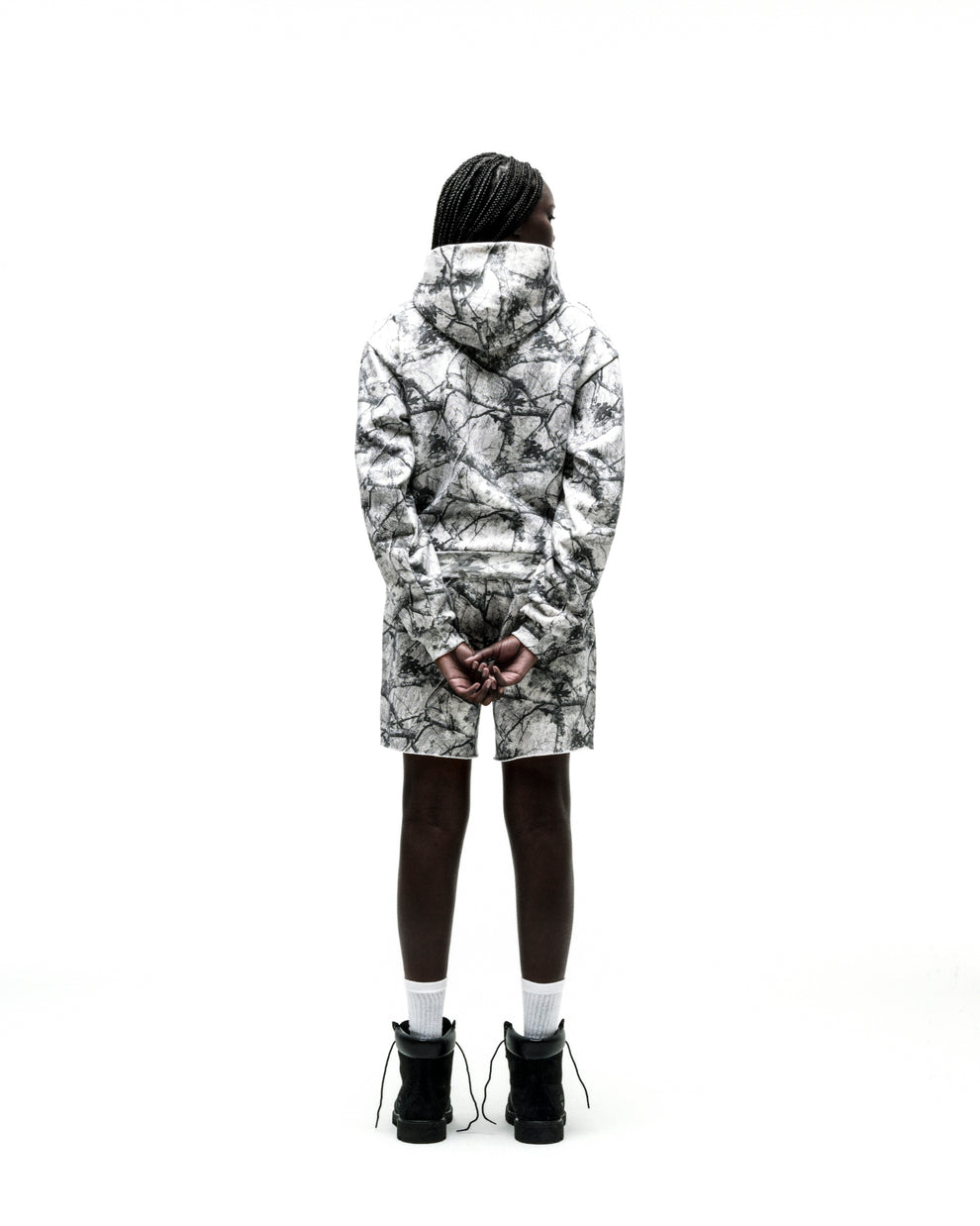 Model from behind wearing a white Realtree camo hoodie and matching sweatshorts with a raw hem.